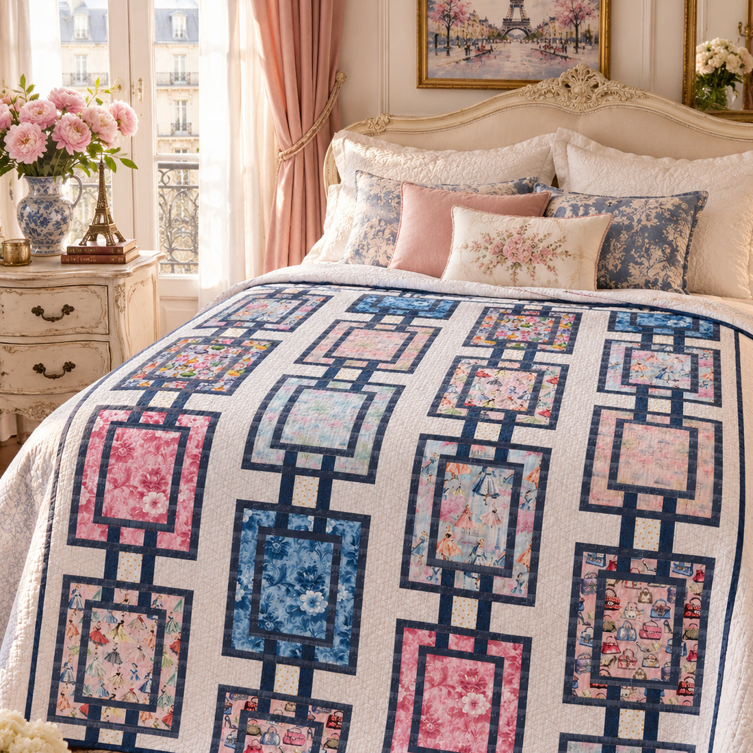 A quilted bedspread with a geometric chain-link pattern in navy blue, pink, and blue floral prints, styled on a bed in a beautifully decorated bedroom.