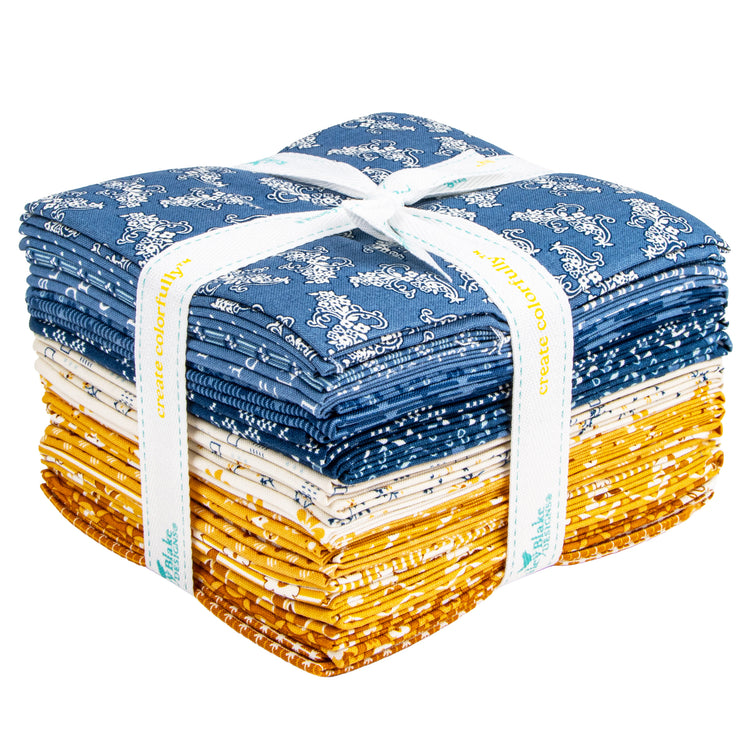 A stack of folded quilting fabrics tied with a white ribbon. The top half features blue fabrics with white floral patterns, and the bottom half features yellow fabrics with a white pattern.