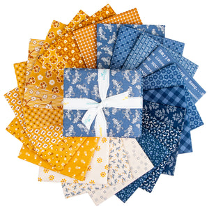 Fabric squares arranged in a circular fan, featuring various patterns and colors including yellow, orange, blue, and cream, with a central blue patterned fabric square tied in a white ribbon bow.