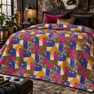 Grunge Gone Glam quilt with gold, magenta and blue patchwork on a bed in a moody industrial bedroom.