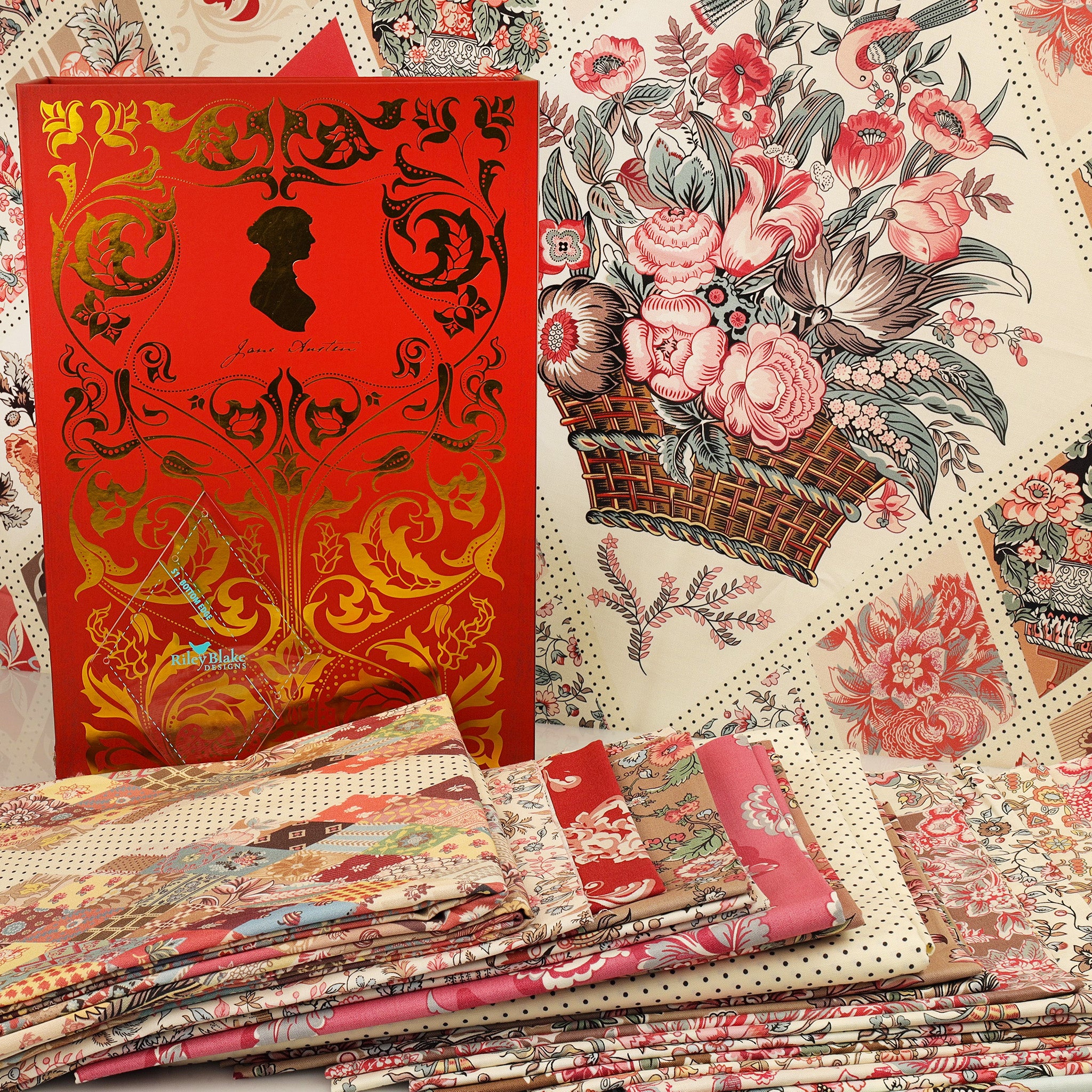 A styled flat-lay of fabric designs, featuring a prominent red box with gold foil detailing and a silhouette of Jane Austen, alongside stacks of patterned fabrics including floral prints, polka dots, and botanical motifs.