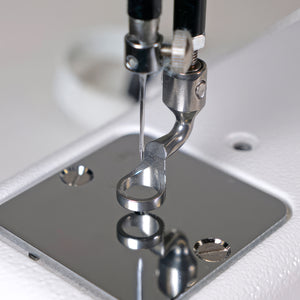 Close-up of a sewing machine needle and presser foot on a white background