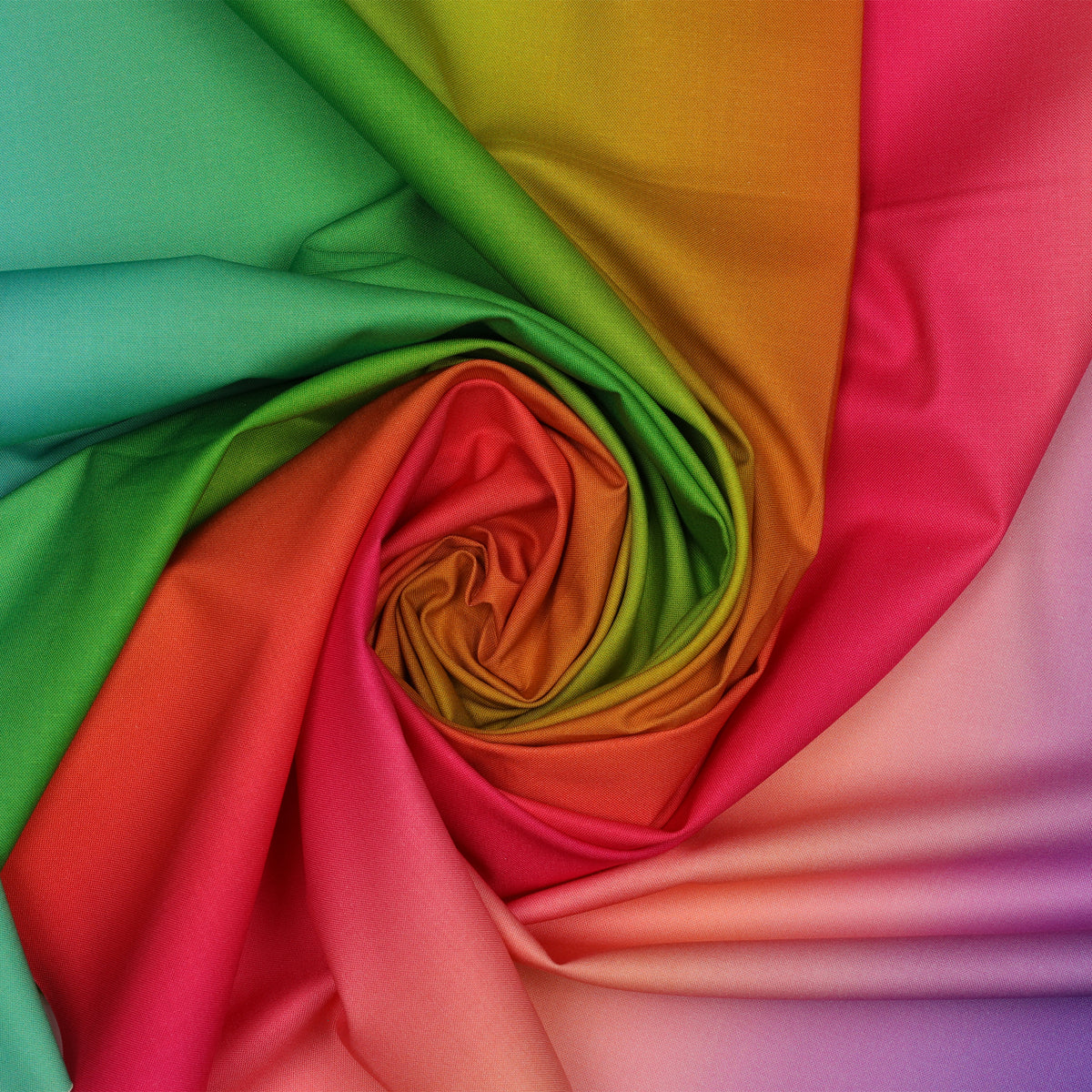 Bright Rainbow Ombre fabric draped in a spiral with bold transitions of turquoise, green, orange, red, pink, and lavender.