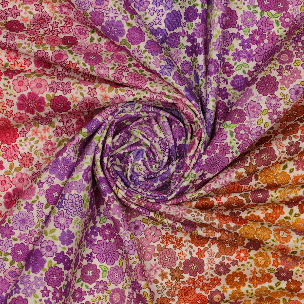Berry Boho Blooms Ombre fabric draped in a spiral with pink, purple, and orange floral patterns.