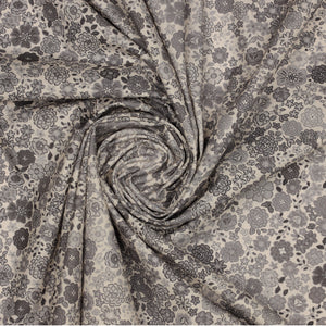 Gray floral fabric with assorted blossoms and leaves, gathered into a spiral.