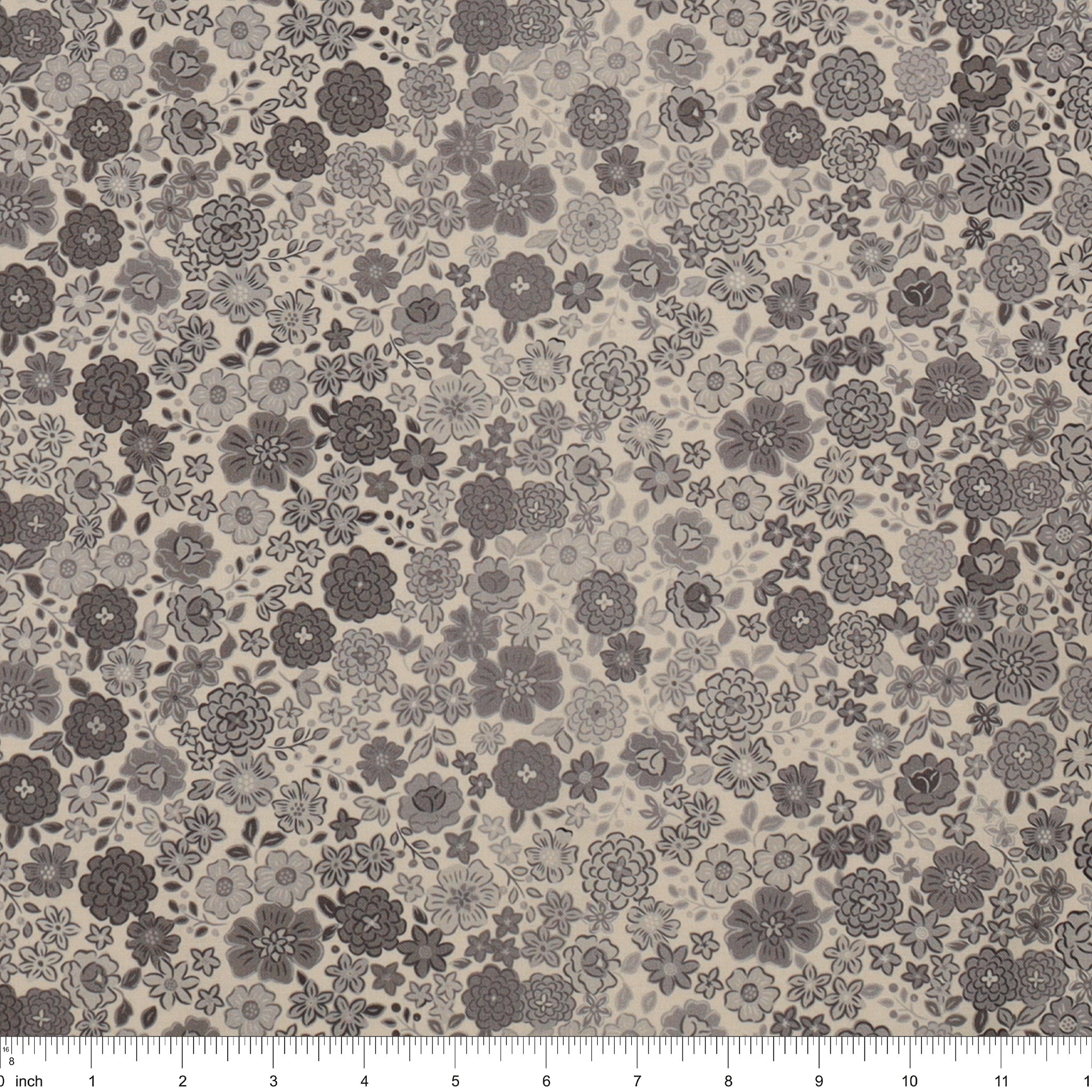 Gray floral fabric with densely scattered flowers in charcoal, taupe, and light gray, shown with a ruler.