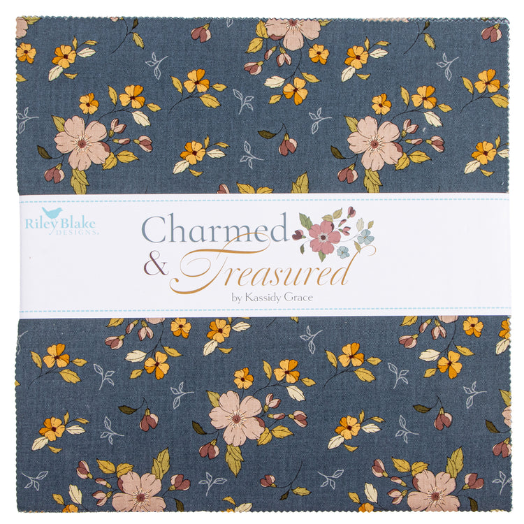 Charmed & Treasured fabrics featuring a dusty slate blue floral pattern with pink, yellow, and orange blossoms, separated by a white paper band.