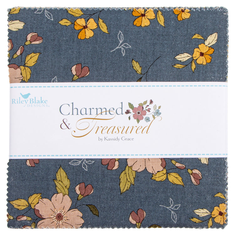 A fabric bundle wrapped with a white band showing a blue-gray floral print with yellow, peach, and muted pink flowers and leaves.