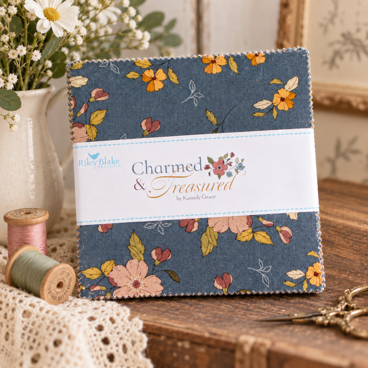 A folded fabric bundle with a floral print on a blue-gray background sits on a wooden table.