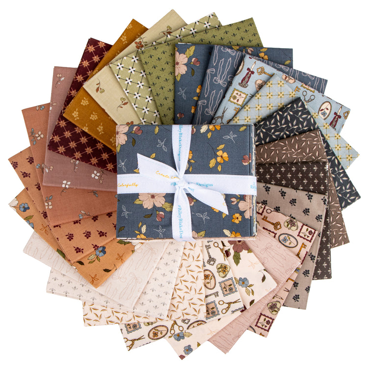 A bundle of fabric squares arranged in a circular fan, with a central folded square tied in a white ribbon.