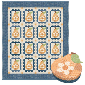 A quilt featuring repeated pears with white flowers and a blue patterned border, shown with a pear shaped keepsake box.