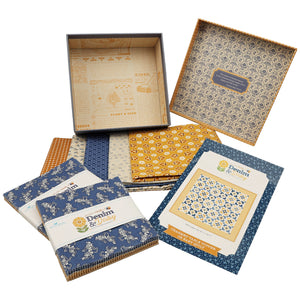 A set of fabric bundles and a patterned gift box. The bundles are wrapped in white paper with blue and gold branding, and the box lid displays a detailed blue and gold geometric pattern.