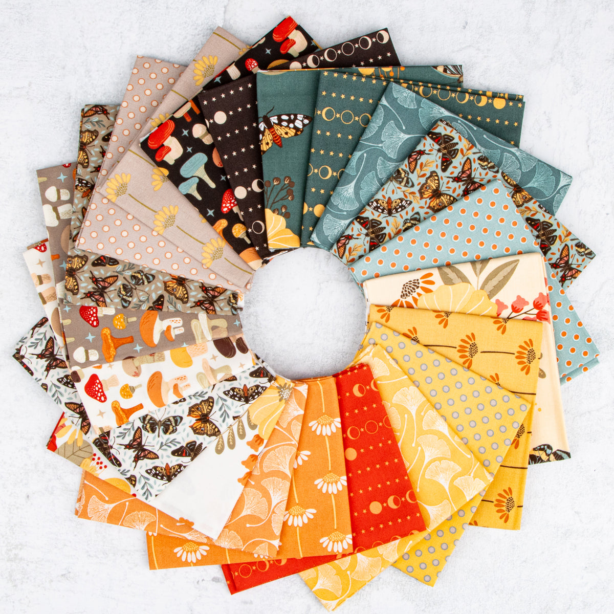 A circular arrangement of multiple patterned fabric swatches in autumn and nature-inspired colors, including orange, yellow, teal, brown, cream, and red, displayed on a light textured background.