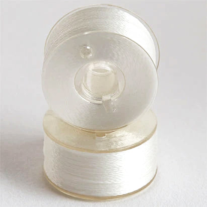 Two stacked clear bobbins with white thread on the bobbins.