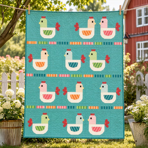Cluck Yeah chicken quilt hanging outdoors with colorful hens on an aqua background.
