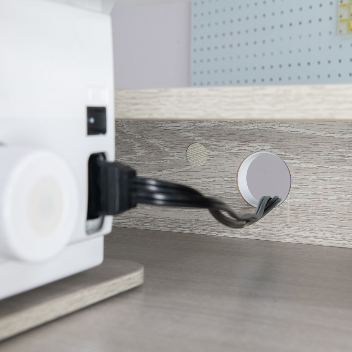 Koala Serger Studio back panel cord grommet with the machine's power cord routed through it