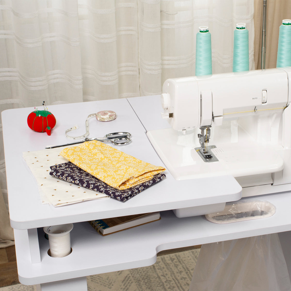 Koala Serger Studio cabinet in white with serger, thread cones, fabric and sewing notions on top