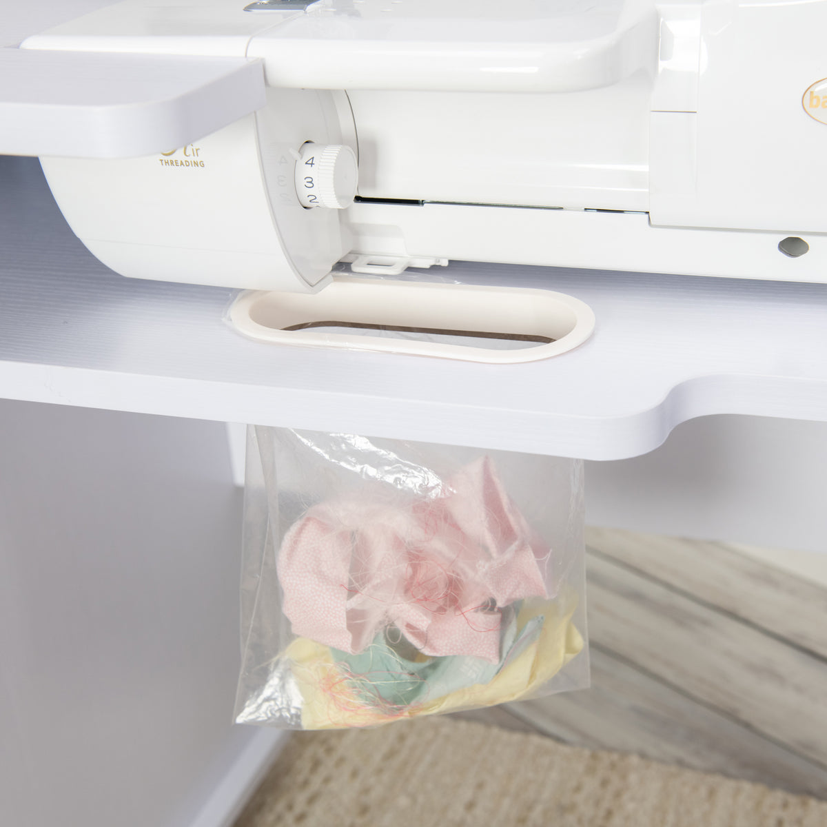 Koala Serger Studio cabinet showing built-in trash slot below serger for catching thread scraps