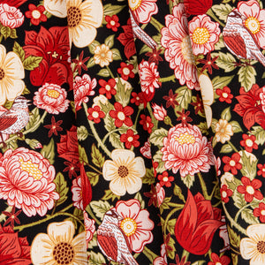 Black fabric with red, pink, and cream flowers, green leaves, and small birds.
