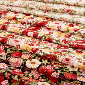 Layered floral fabrics in cream, pink, red, green, and black with birds and garden blooms.