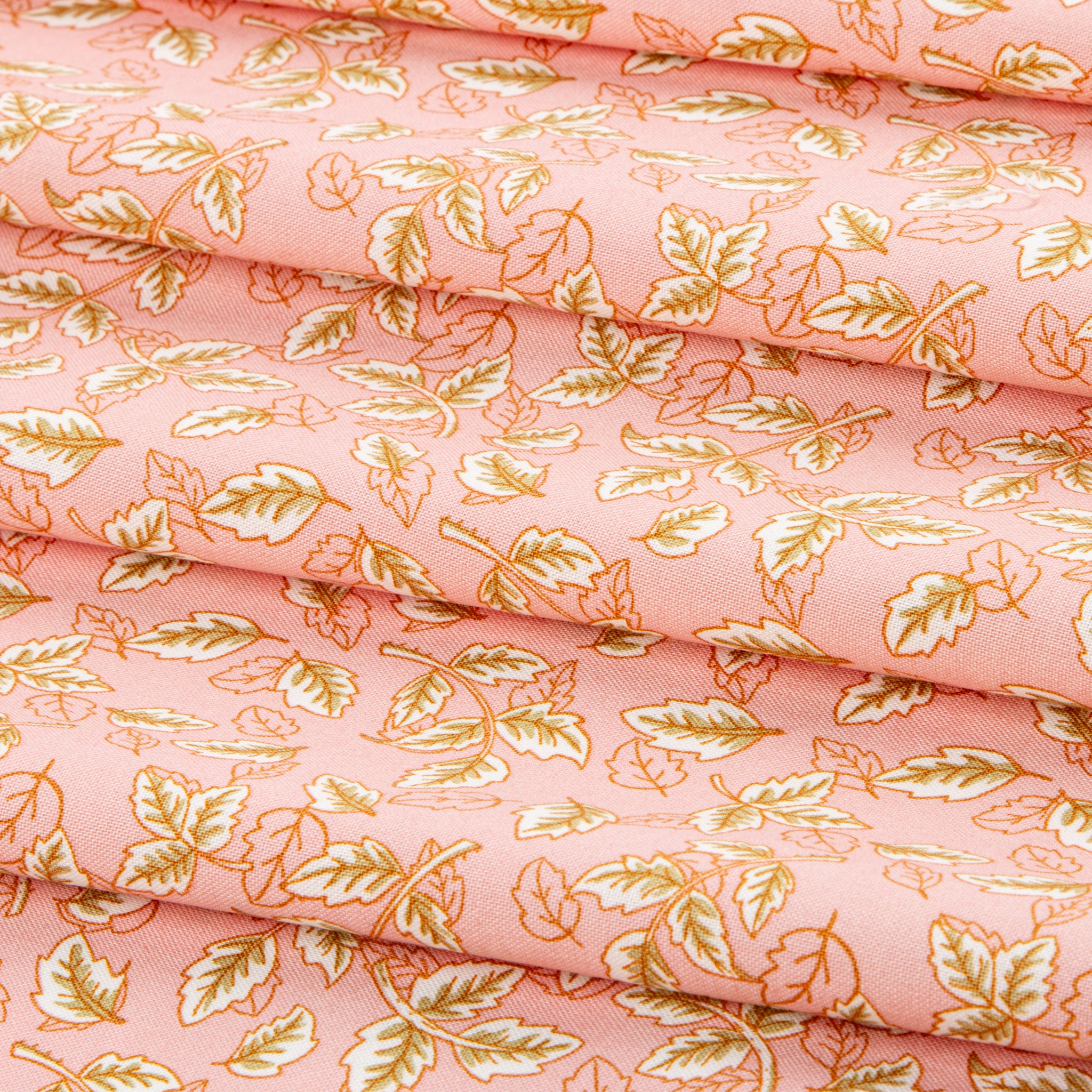 Blush pink fabric with scattered cream and golden leaf motifs.