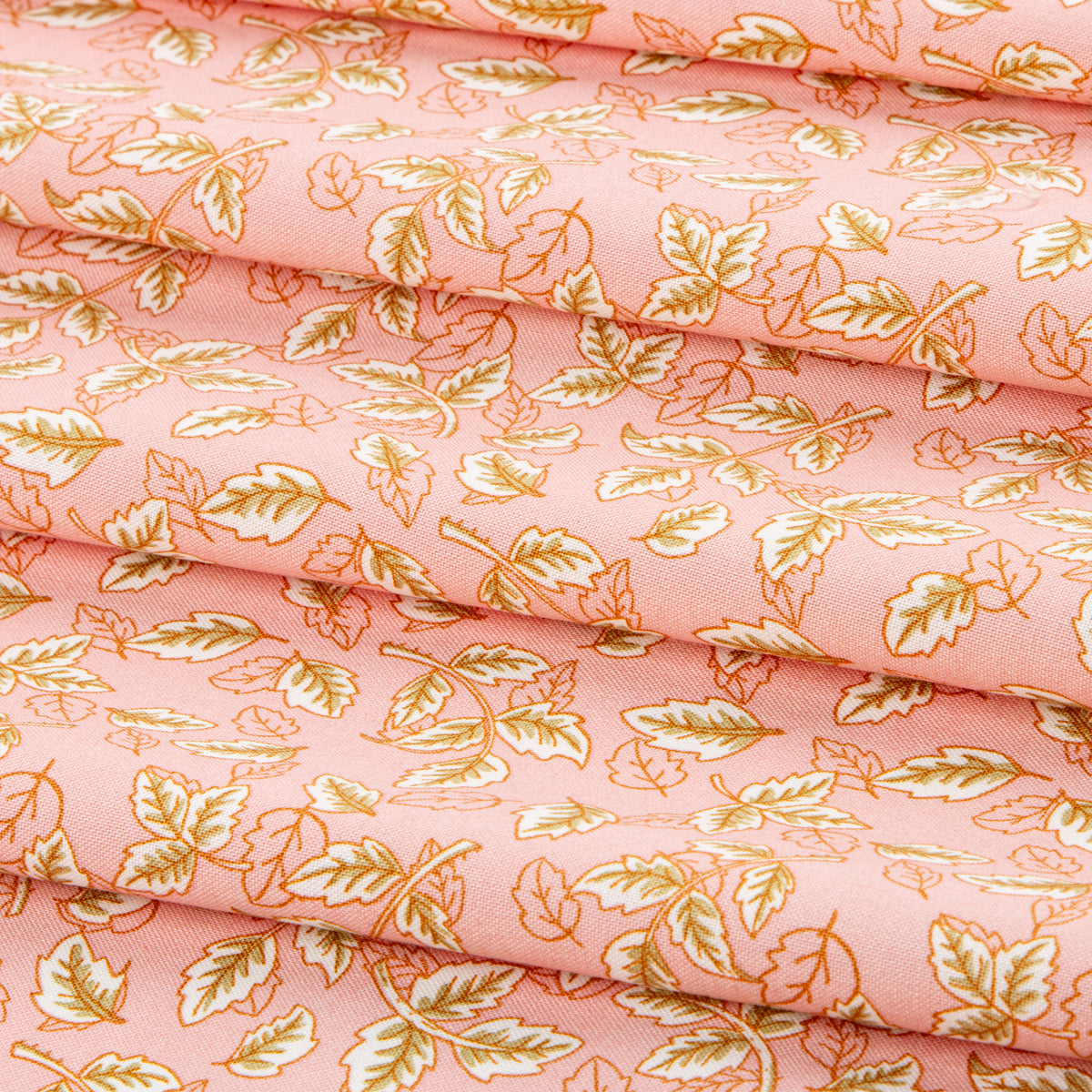 Blush pink fabric with scattered cream and golden leaf motifs.