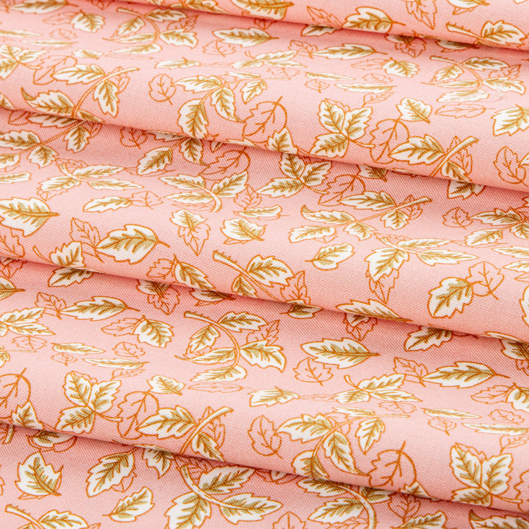 Blush pink fabric with scattered cream and golden leaf motifs.