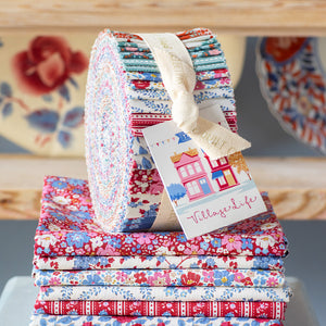 Tilda Village Life Fabric Roll with colorful precut floral strips displayed with coordinating folded fabrics.