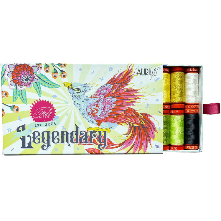 A box of Aurifil Tula Pink 'Legendary' sewing thread, showing the illustrated packaging and a side window revealing six colorful threads in yellow, white, green, orange, black, and red.