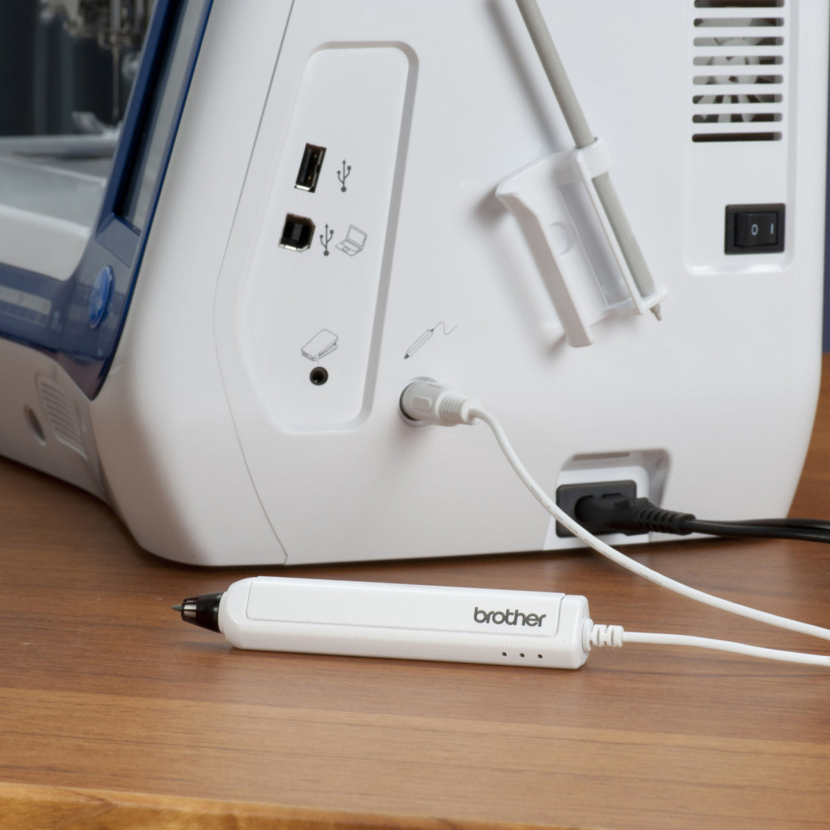Brother Sensor Pen on a wood desk with a sewing machine in the background