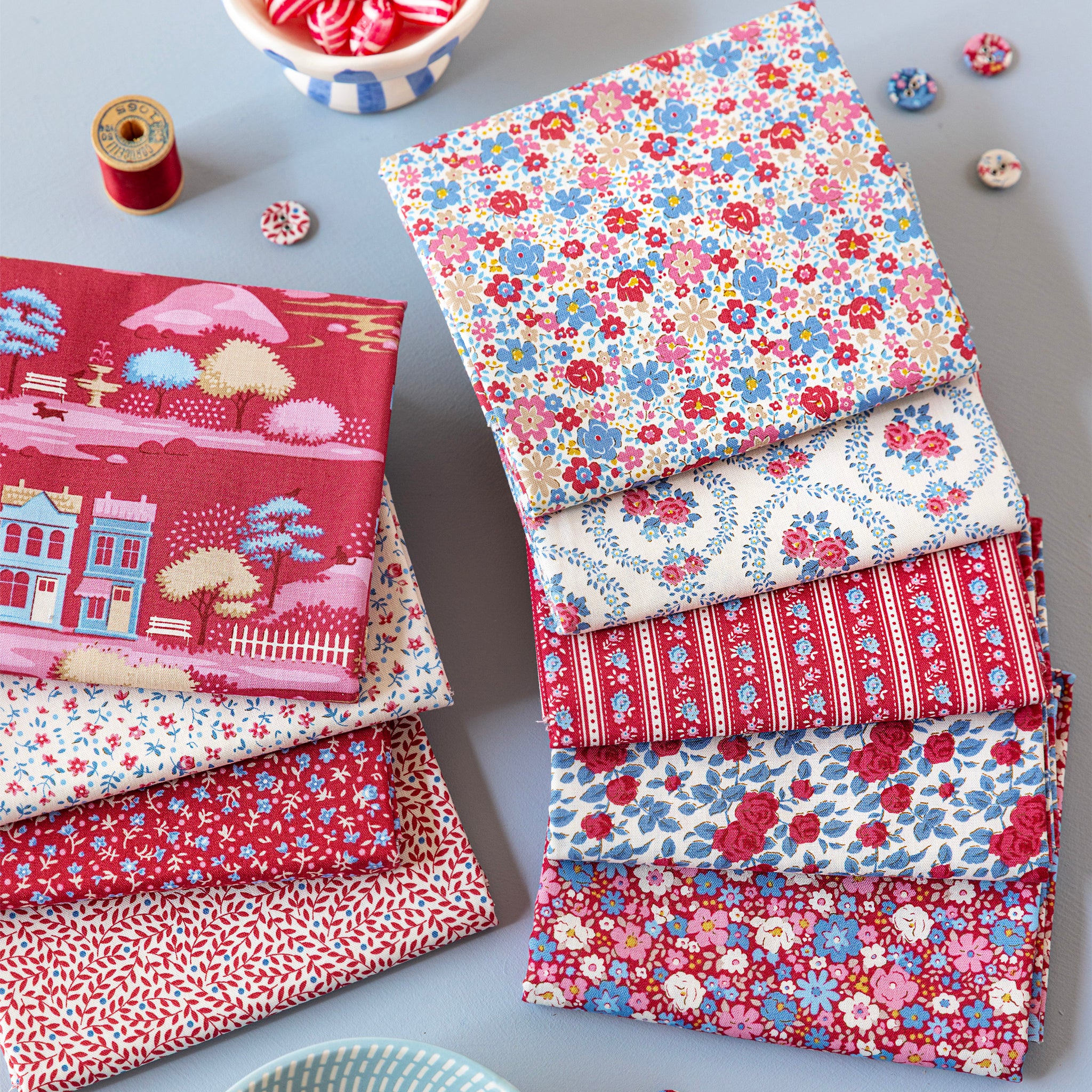 Folded Village Life fabrics in red, blue and cream floral and village prints.