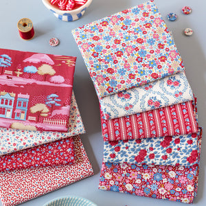 Folded Village Life fabrics in red, blue and cream floral and village prints.