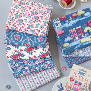 Folded Village Life fabrics in blue, red and cream floral and village patterns.