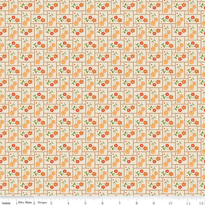 Small orange flowers with green leaves on a patchwork pattern with a ruler along the bottom for scale. 