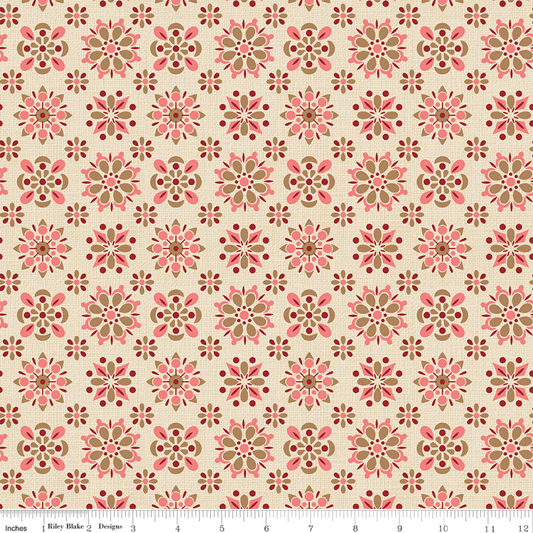 Patterned fabric with pink and brown flowers on a beige background with a ruler along the bottom for scale. 